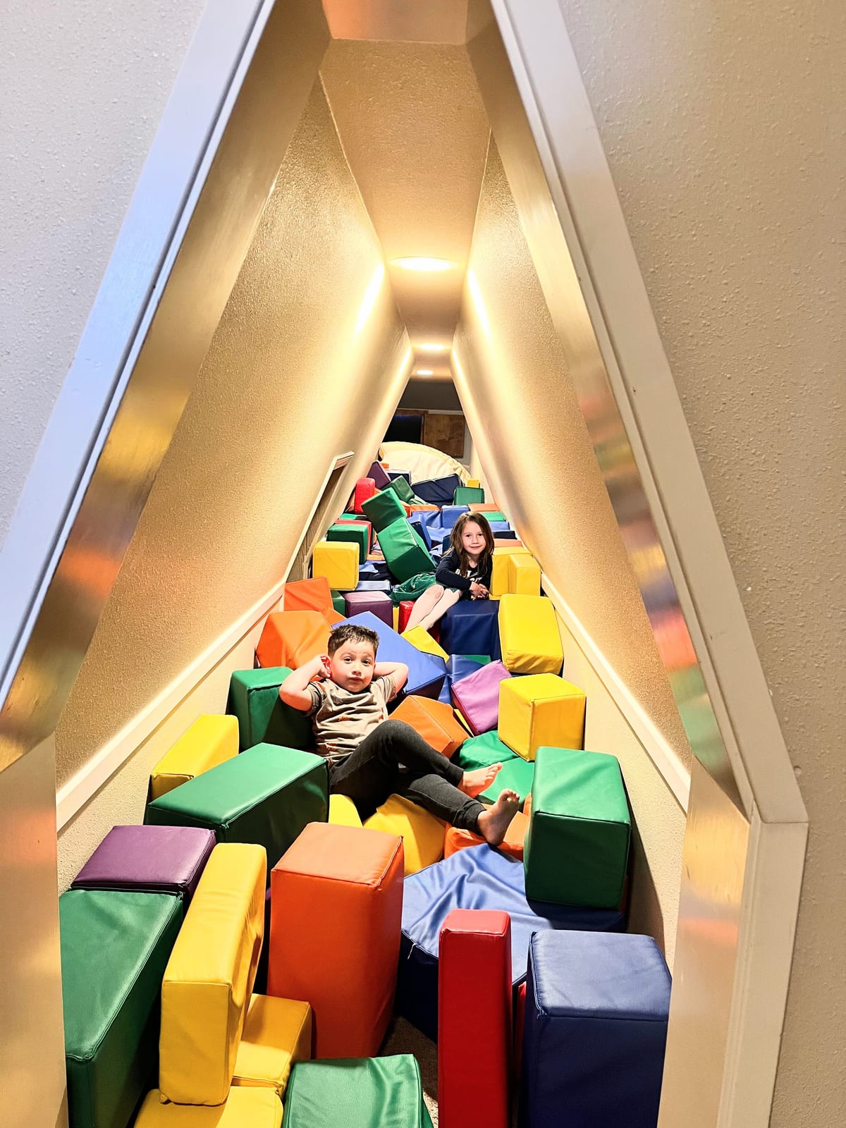 Kids in the passage with a pile of soft blocks